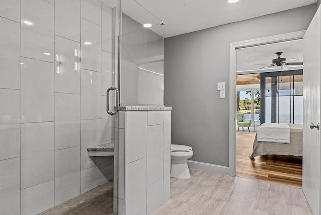 bathroom with an enclosed shower, ceiling fan, and toilet