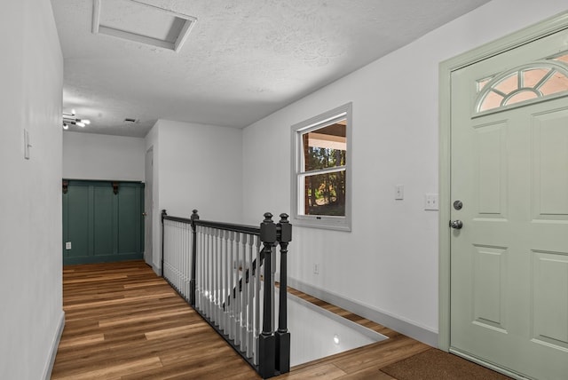 entryway with dark hardwood / wood-style floors and a textured ceiling