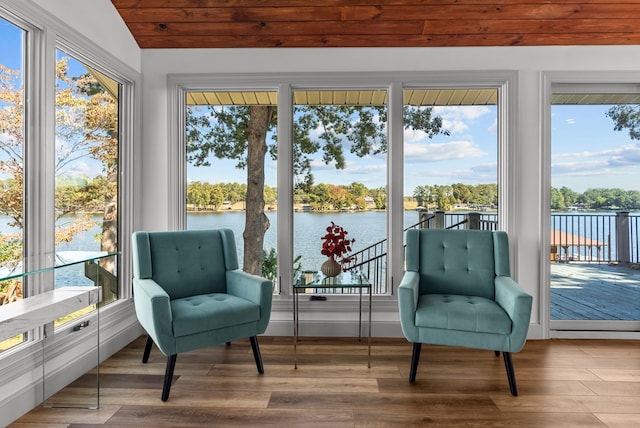 sunroom / solarium with a healthy amount of sunlight, a water view, and lofted ceiling