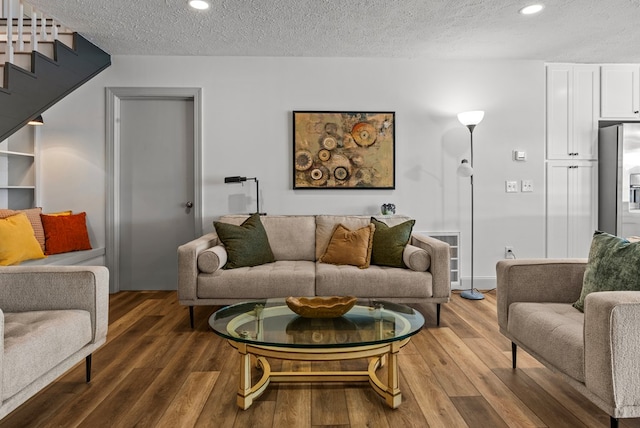 living room with a textured ceiling and hardwood / wood-style flooring