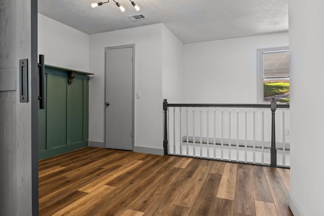 additional living space with a textured ceiling and dark wood-type flooring