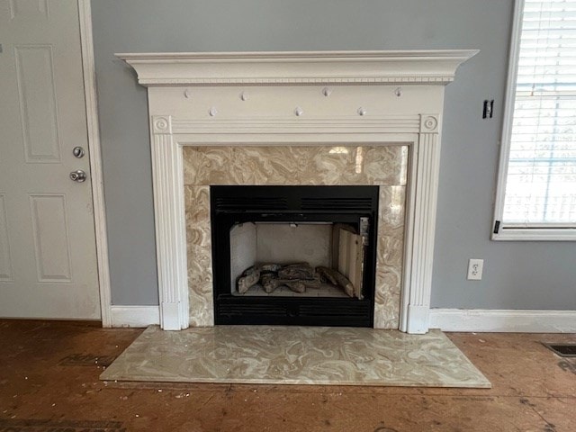 room details featuring visible vents, baseboards, and a fireplace with raised hearth