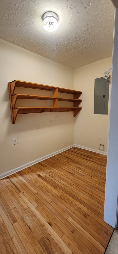 walk in closet featuring wood finished floors and electric panel