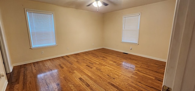 spare room featuring ceiling fan, visible vents, light wood-style flooring, and baseboards