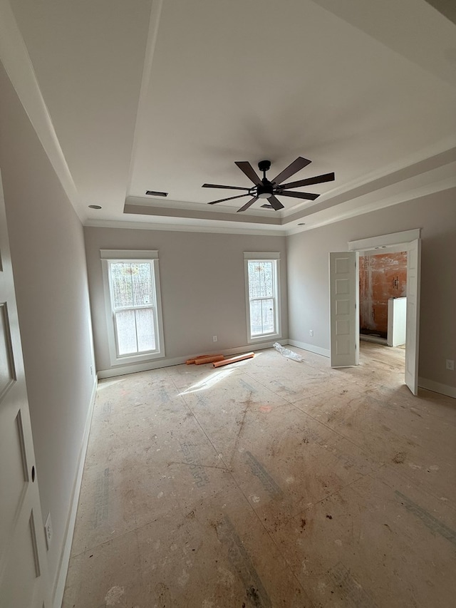 unfurnished room with ceiling fan, plenty of natural light, and a raised ceiling