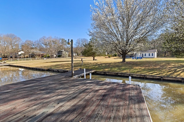 view of dock featuring a yard and a water view