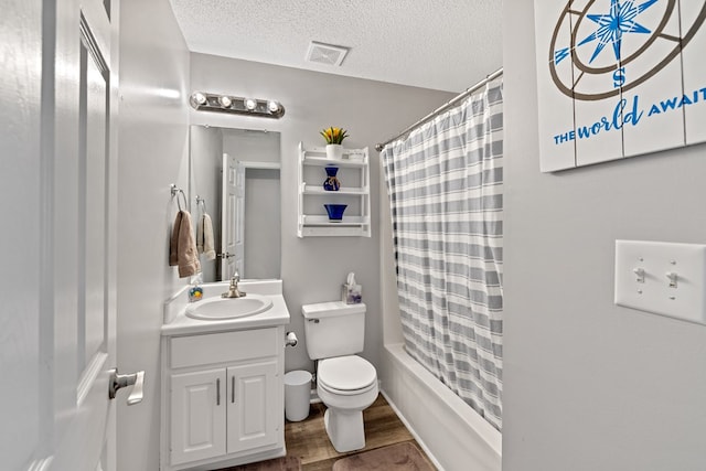 full bath featuring visible vents, toilet, vanity, wood finished floors, and a textured ceiling