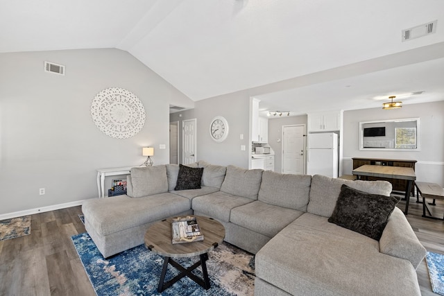 living room featuring visible vents, wood finished floors, and vaulted ceiling