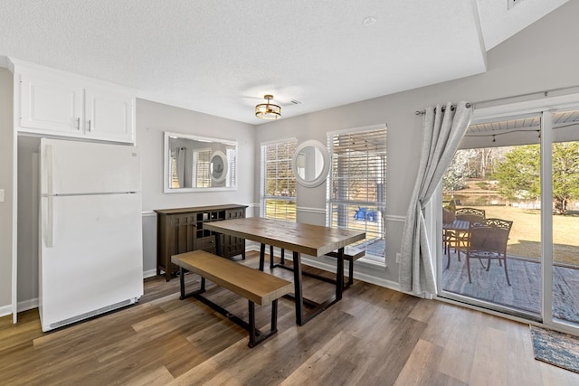 dining room featuring a textured ceiling and wood finished floors