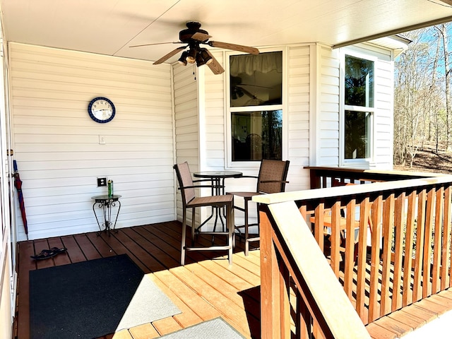 wooden deck featuring a ceiling fan and outdoor dining space