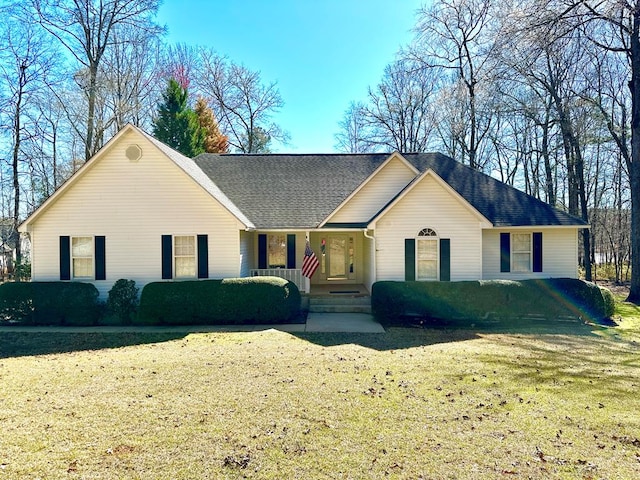 ranch-style home with a shingled roof and a front yard