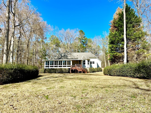 view of front of property featuring a sunroom and a front lawn