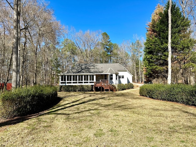 back of property featuring a sunroom and a lawn