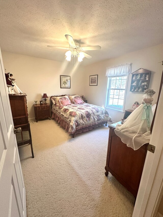 bedroom featuring a textured ceiling, a ceiling fan, and carpet flooring