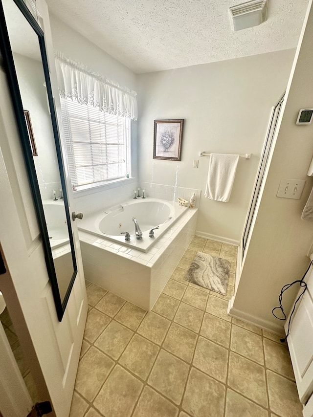 full bathroom featuring a whirlpool tub, visible vents, a textured ceiling, and tile patterned floors