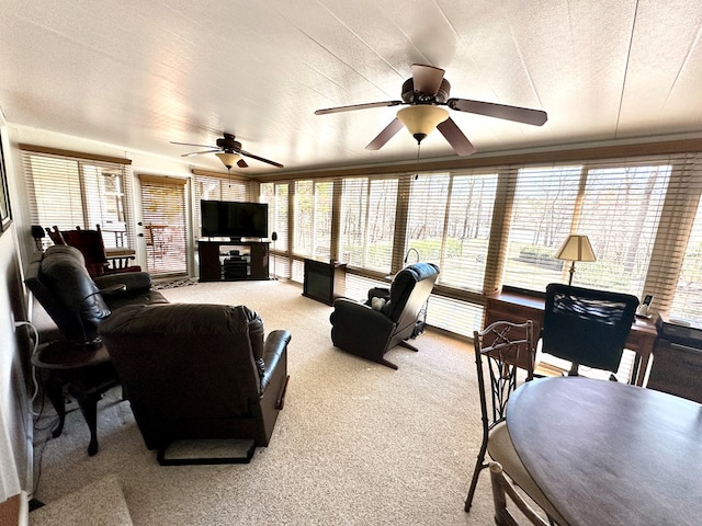 carpeted living area with a textured ceiling and ceiling fan