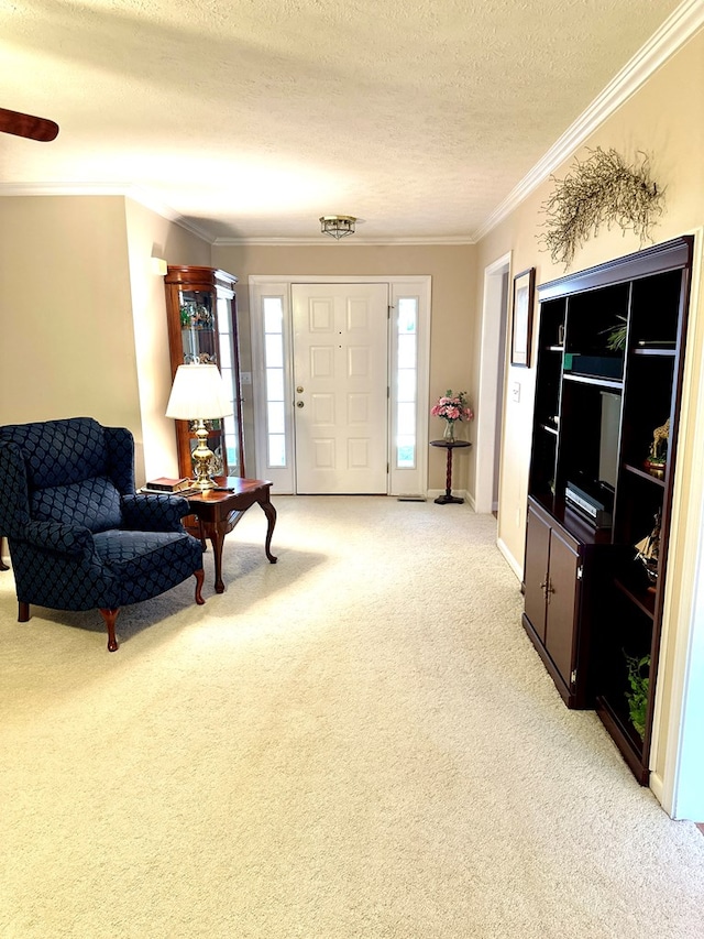 foyer entrance with ornamental molding, light colored carpet, and a textured ceiling