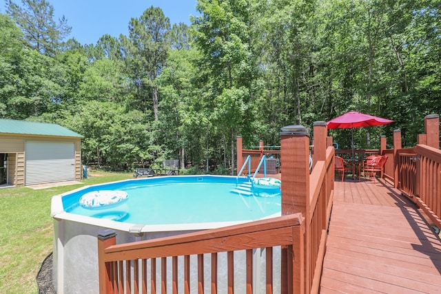 287 Napier Rd, Eatonton, GA 31024 - outdoor pool featuring a wooden deck, outdoor dining space, a lawn, and an outbuilding