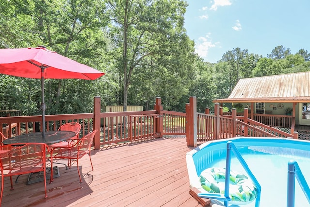 287 Napier Rd, Eatonton, GA 31024 - deck with outdoor dining space, view of scattered trees, and an outdoor pool