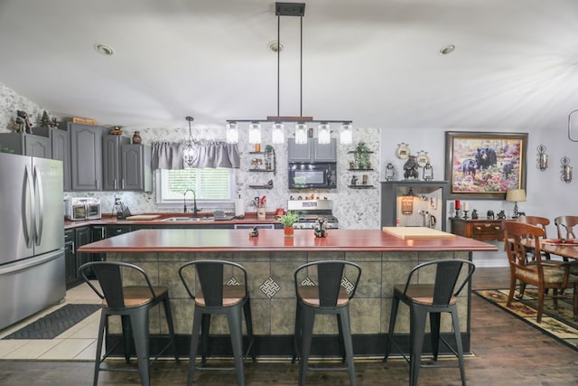 287 Napier Rd, Eatonton, GA 31024 - kitchen with appliances with stainless steel finishes, a sink, a kitchen breakfast bar, dark wood finished floors, and dark countertops