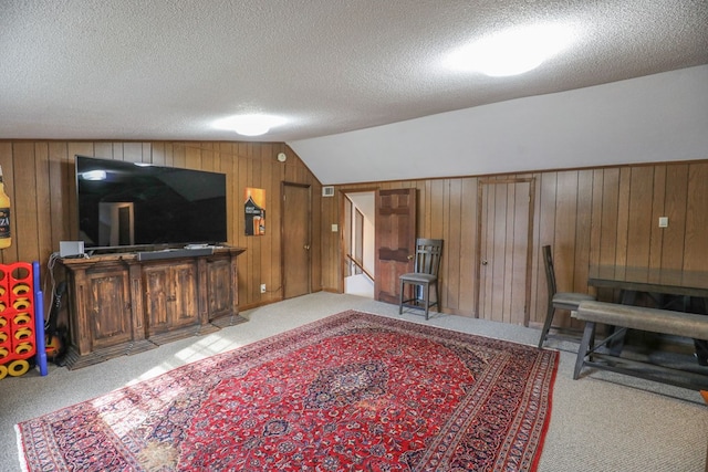 3715 Sinclair Dam Rd, Milledgeville, GA 31061 - carpeted living area with wood walls, vaulted ceiling, and a textured ceiling