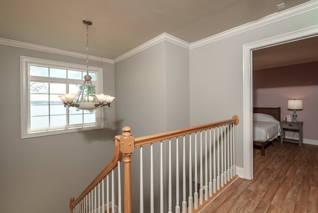 116 Island Dr, Milledgeville, GA 31061 - hallway with an upstairs landing, a chandelier, wood finished floors, ornamental molding, and plenty of natural light