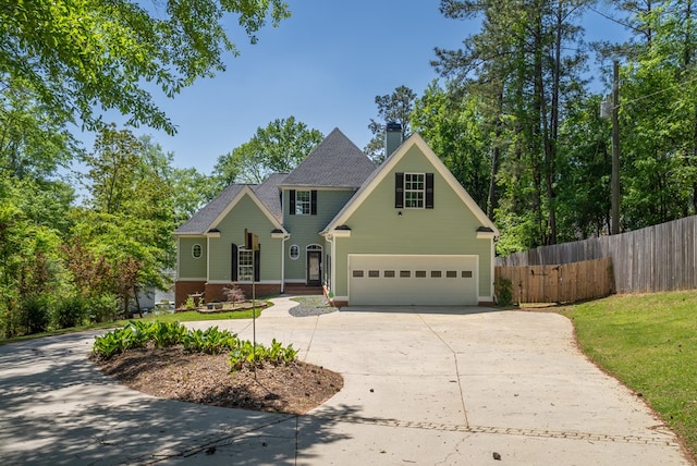 116 Island Dr, Milledgeville, GA 31061 - view of front of home with fence, concrete driveway, a chimney, and an attached garage