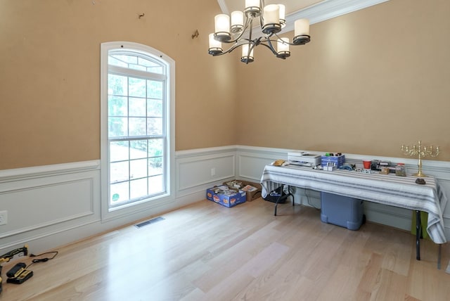 116 Island Dr, Milledgeville, GA 31061 - dining area featuring a wainscoted wall, a chandelier, light wood-style flooring, and a decorative wall