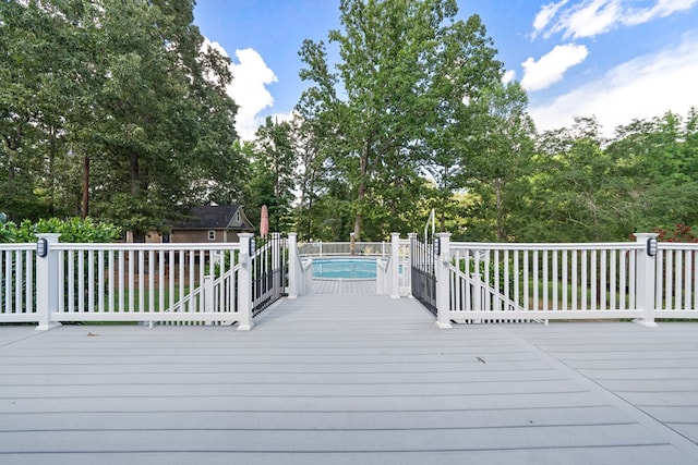 wooden terrace with a fenced in pool