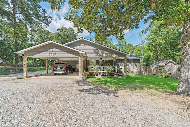 view of front facade featuring a porch, a carport, and a front lawn