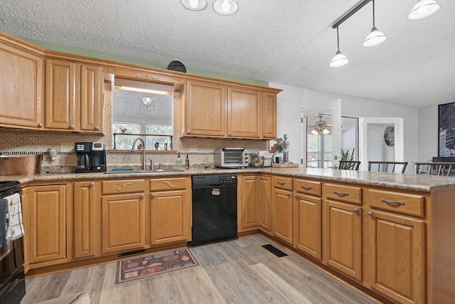 kitchen featuring sink, light hardwood / wood-style flooring, kitchen peninsula, pendant lighting, and black appliances