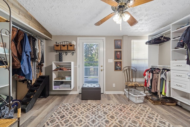 walk in closet featuring wood-type flooring and ceiling fan