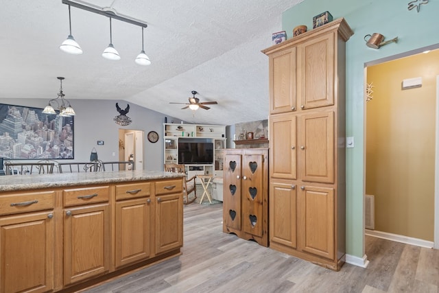 kitchen featuring decorative light fixtures, light hardwood / wood-style floors, ceiling fan with notable chandelier, and vaulted ceiling