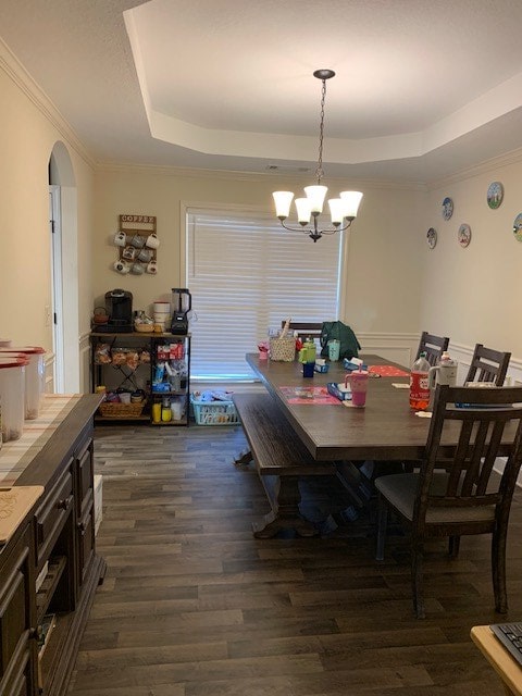 1683 Sara Hunter Ln, Milledgeville, GA 31061 - dining space featuring a tray ceiling, dark wood-style flooring, a chandelier, arched walkways, and ornamental molding