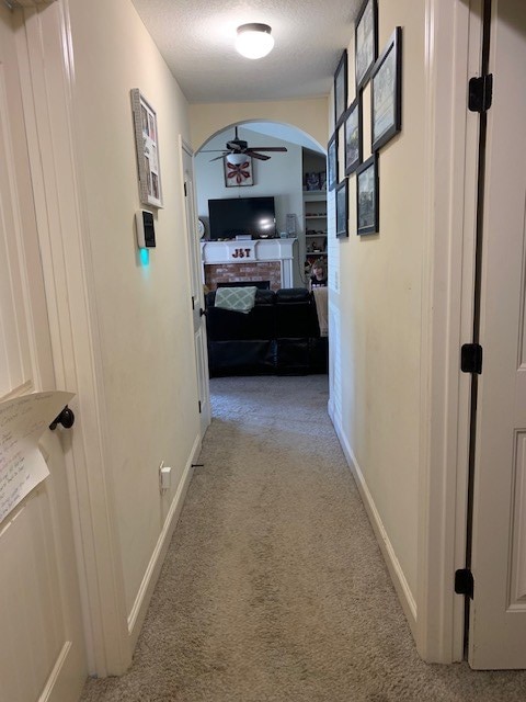 1683 Sara Hunter Ln, Milledgeville, GA 31061 - corridor with light colored carpet, arched walkways, and a textured ceiling