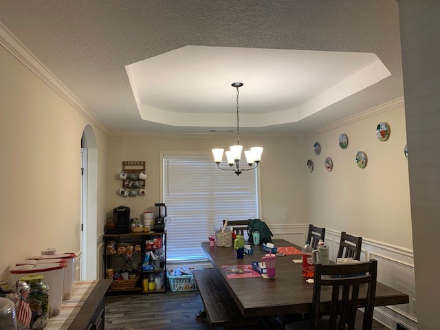 1683 Sara Hunter Ln, Milledgeville, GA 31061 - dining room with a raised ceiling, a chandelier, dark wood-style flooring, crown molding, and arched walkways