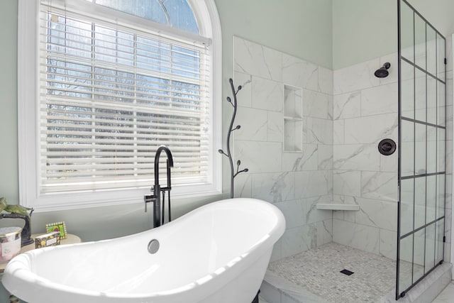 bathroom with shower with separate bathtub and a wealth of natural light