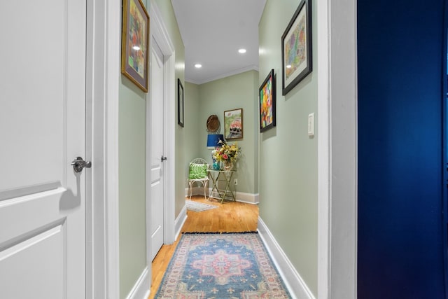 hall with hardwood / wood-style floors and ornamental molding