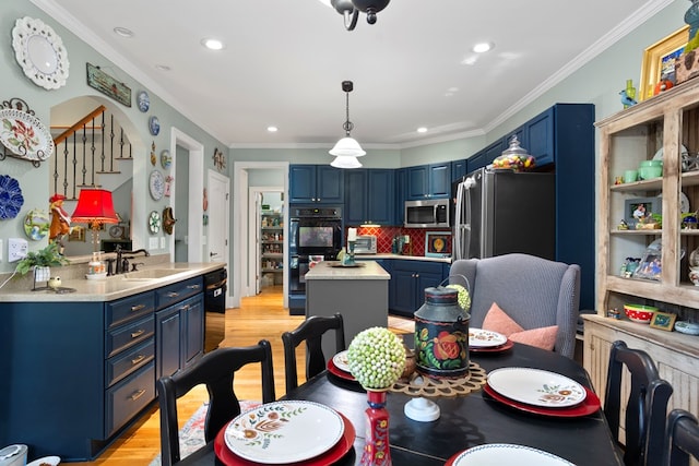 dining area with ornamental molding, sink, and light hardwood / wood-style flooring