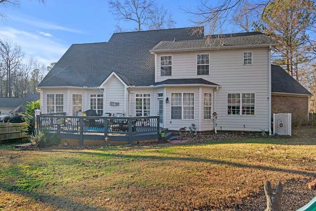 back of property featuring a lawn and a deck