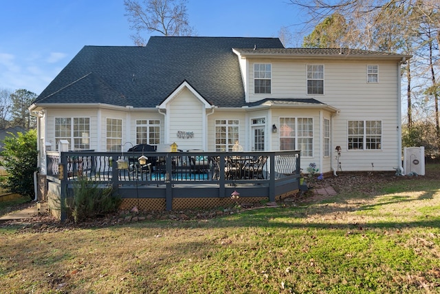 rear view of house with a wooden deck and a yard