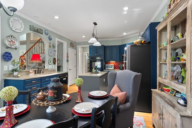 dining space featuring sink and ornamental molding