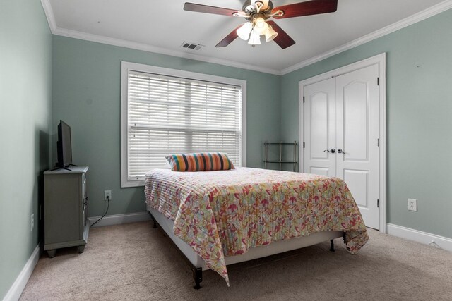 bedroom featuring ensuite bathroom, ceiling fan, light colored carpet, and crown molding