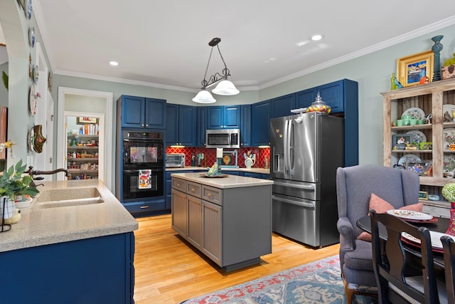 kitchen featuring stainless steel appliances, a kitchen island, hanging light fixtures, and light hardwood / wood-style floors