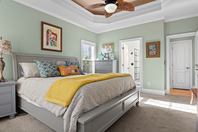 bedroom with ceiling fan, a raised ceiling, ornamental molding, and light carpet