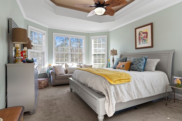 bedroom featuring ceiling fan, carpet floors, crown molding, and a tray ceiling