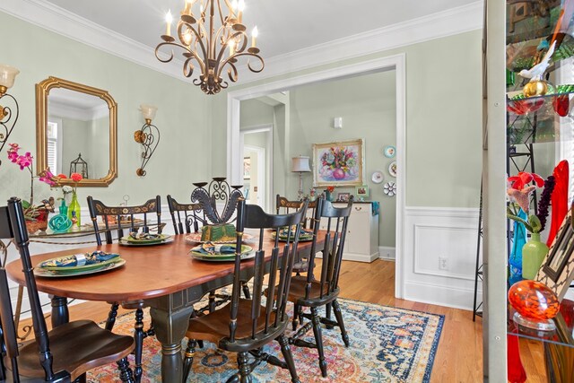 dining room with light hardwood / wood-style flooring, a chandelier, and ornamental molding