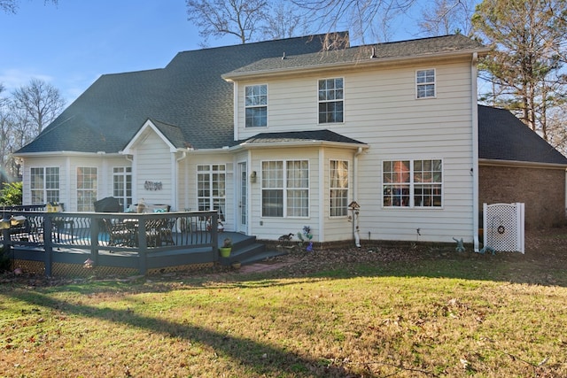 back of property featuring a wooden deck and a lawn