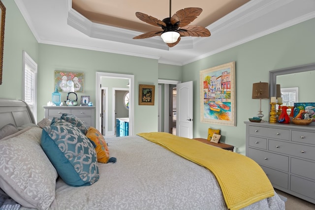 bedroom featuring ensuite bathroom, crown molding, carpet flooring, a raised ceiling, and ceiling fan