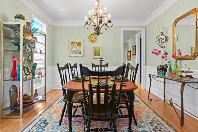 dining room with crown molding, light hardwood / wood-style floors, and a notable chandelier